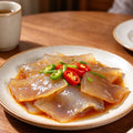 Glassy amber jellyfish slices dressed with chilli and spring onion