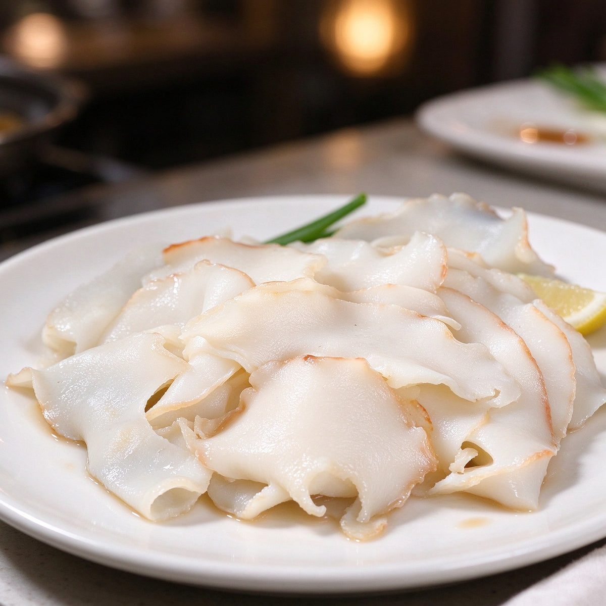 Thin white slices of conch meat with a golden rim