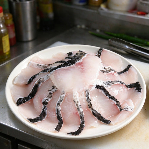 Boneless snakehead fillets with dark skin edge on a white plate